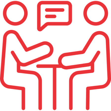 Two figures discussing at a table icon.