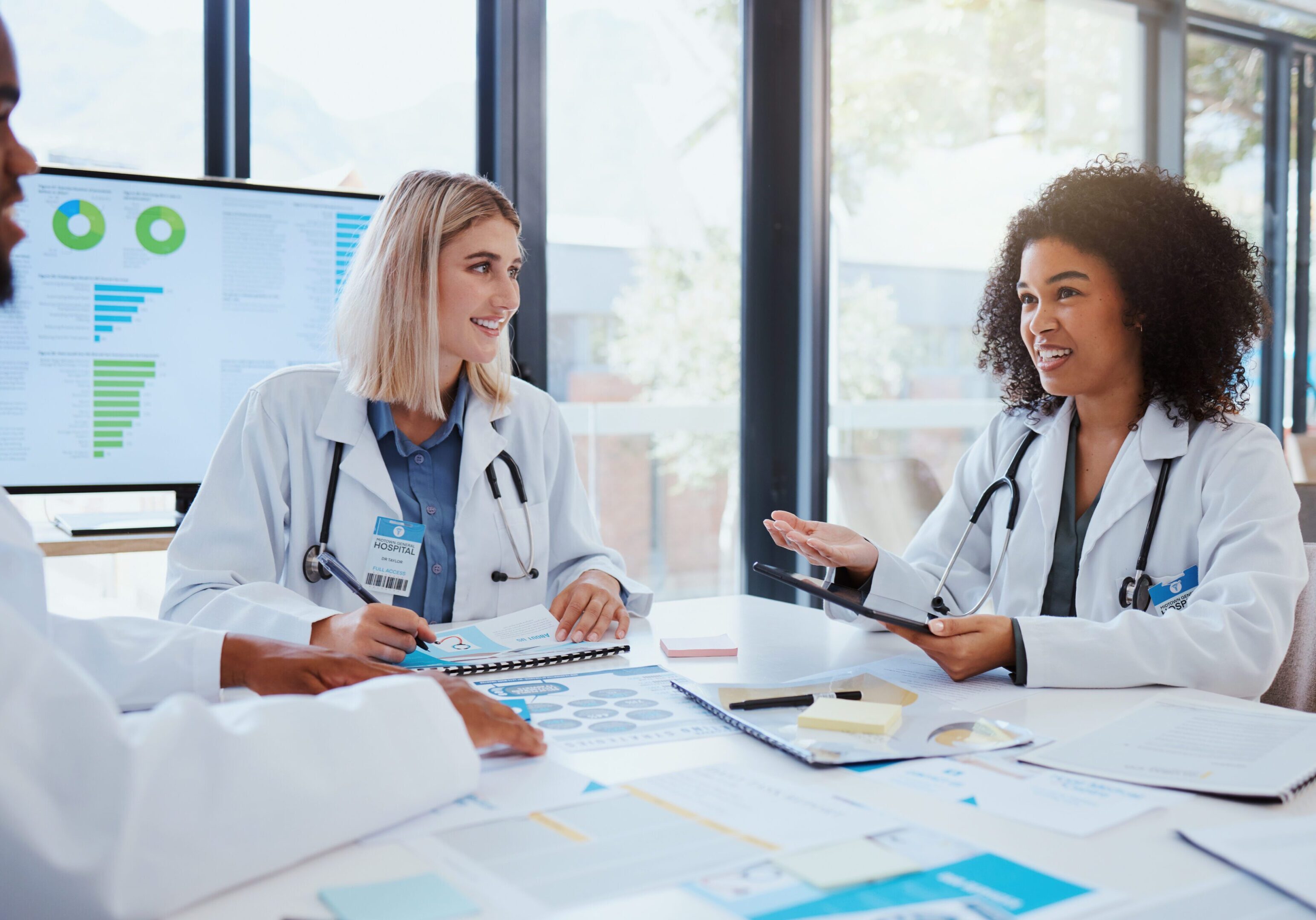 Doctors discussing medical charts in meeting.