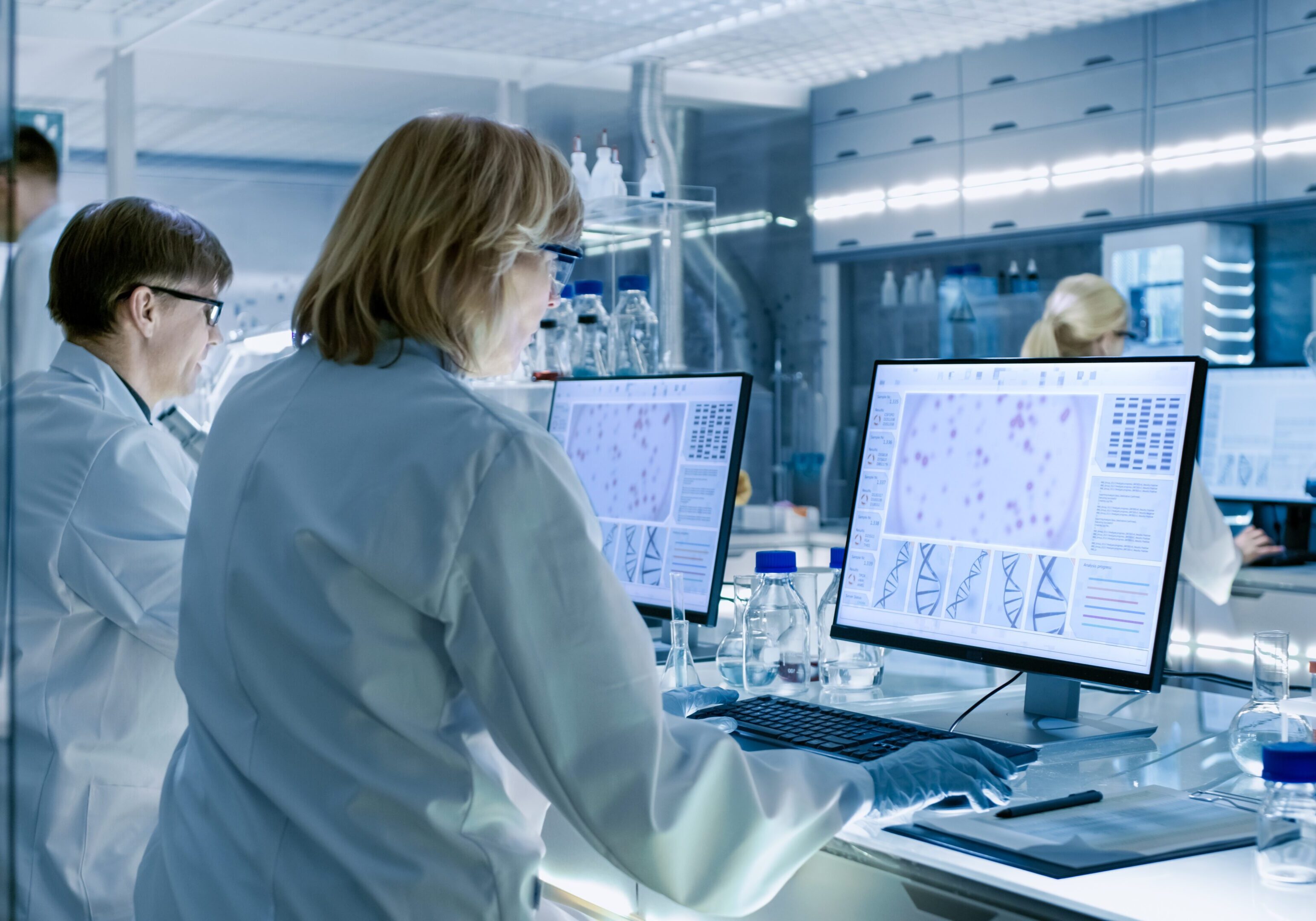 Scientists analyzing data on computer screens.